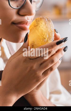 vue rognée de l'artisan afro-américain appréciant la saveur du savon maison, image de stock Banque D'Images