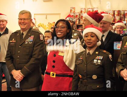 Major général Mark T. Simerly, CASCOM et commandant général de fort Lee; Alexis Bowles-Fryar, représentant de la sensibilisation, Bureau des États-Unis Le sénateur Mark Warner; et le Sgt de commandement Maj. Tamisha Love, garnison CSM, se moque avec plaisir tandis que les enfants du Centre de développement de l'enfant de Battle Drive chantent des chants de Noël. Banque D'Images