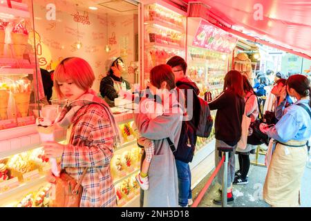 Tokyo, Harajuku, rue Takeshita. Angel Crepes emporter avec un présentoir en plastique autour du comptoir où les gens sont servis avec leur commande. Banque D'Images