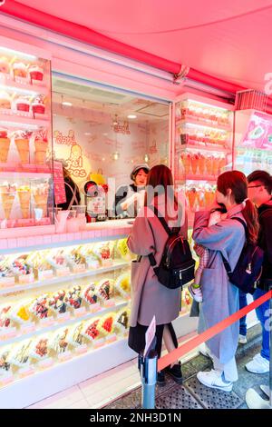 Tokyo, Harajuku, rue Takeshita. Angel Crepes emporter avec un présentoir en plastique autour du comptoir où les gens sont servis avec leur commande. Banque D'Images