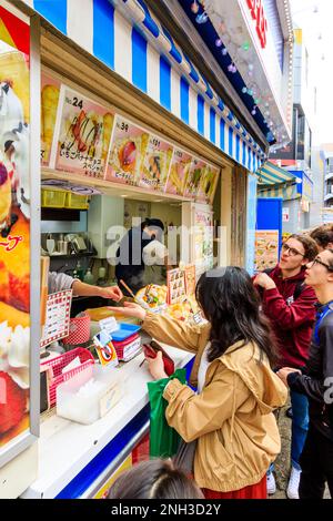 Tokyo, Harajuku, rue Takeshita. Marion Crepe enrater avec des gens qui font la queue au comptoir en attendant de commander et d'être servis leurs crêpes. Gros plan. Banque D'Images
