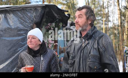 Un homme et une femme sans domicile donnant une interview en hiver dans les bois. Banque D'Images