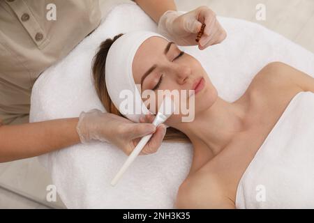 Jeune femme au cours de la procédure de peeling du visage dans le salon Banque D'Images