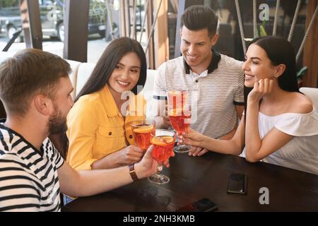 Des amis avec des cocktails Aperol spritz se reposent ensemble au restaurant Banque D'Images