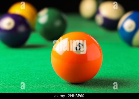 Boule de billard avec numéro 5 sur table verte, gros plan Banque D'Images