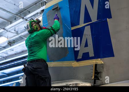 221210-N-PA221-1104 OCÉAN PACIFIQUE (10 DÉCEMBRE 2022) ÉTATS-UNIS Navy Aviation Structural Mechanic 1st Class John Rosales, de Menifee, en Californie, peint le logo de l'escadron sur la queue d'un F/A-18F Super Hornet du 'Fighting Redcocks' de l'escadron de combat Strike Fighter Squadron (VFA) 22 à bord du porte-avions USS Nimitz (CVN 68). Nimitz mène actuellement des opérations de routine. Banque D'Images