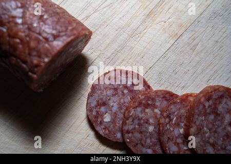Saucisse à l'ail tranchée sur une planche à découper en bois Banque D'Images