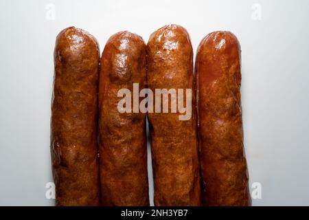 Quatre saucisses frites sur fond blanc Banque D'Images