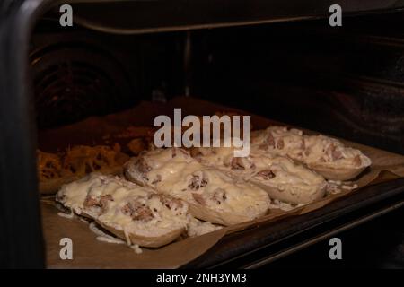 Sandwichs coupés en deux avec du thon et du fromage fondu au four Banque D'Images