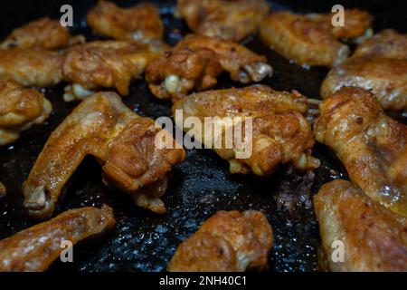 Des ailes de poulet grillées croustillantes sur une plaque de cuisson Banque D'Images