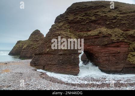 Vagues s'écrasant à travers une arche nautrale le long du sentier côtier Angus. Banque D'Images