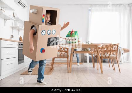 Petit garçon en costume robot en carton jouant à la maison Banque D'Images