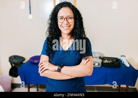 Femme thérapeute physique afro-américaine à bras croisés. Femme souriante chiropracteur en uniforme avec les bras croisés, Portrait de femme souriante Banque D'Images