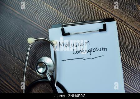 Concept de Moluskum Contagiosum écrire sur la paperasse avec stéthoscope isolé sur la table en bois. Banque D'Images