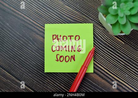 Concept de photo à venir écrire sur des notes adhésives isolées sur la table en bois. Banque D'Images