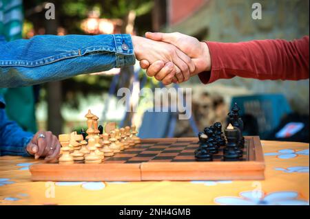 Gros plan. Que le jeu commence. Couple jouant une partie d'échecs, le jour du printemps, à l'extérieur. Banque D'Images