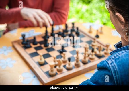 Gros plan. Que le jeu commence. Couple jouant une partie d'échecs, le jour du printemps, à l'extérieur. Banque D'Images