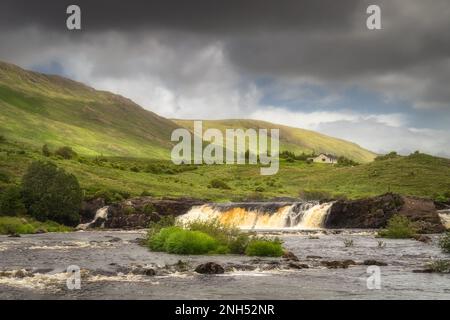 Aasleagh Falls sur la rivière Erriff avec une seule maison sous les montagnes Letterass avec adrk ciel spectaculaire en arrière-plan, comté Mayo, Irlande Banque D'Images