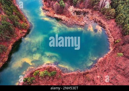 Rivière polluée avec du titane et d'autres composés métalliques colorés, indiquant la présence de dépôts métalliques à proximité. L'eau contaminée pose une thre Banque D'Images