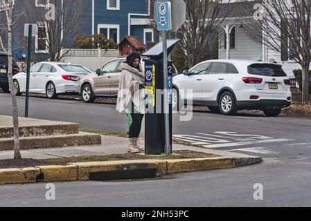 Femme habillée de façon tendance paie pour le parking, les villes préférées de New Hope-America par Travel + Leisure. Pennsylvanie, États-Unis Banque D'Images