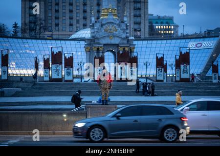 Kiev, Ukraine - 20 février 2023 : un ukrainien militaire en uniforme porte le drapeau de guerre au Maïdan Nezalezhnosti, la place centrale de Kiev. Le drapeau de l'armée insurrectionnelle ukrainienne, également connu sous le nom de drapeau rouge et noir de l'Ukraine, est un drapeau utilisé auparavant par l'Armée insurrectionnelle ukrainienne (UPA) et l'Organisation des nationalistes ukrainiens de Banderite (OUN), Et maintenant utilisé par divers partis et organisations nationalistes ukrainiens, dont L'UNA-UNSO, le secteur droit, le Congrès des nationalistes ukrainiens et d'autres. Le drapeau se compose de deux couleurs : rouge et noir. La couleur noire symbolise la bl Banque D'Images