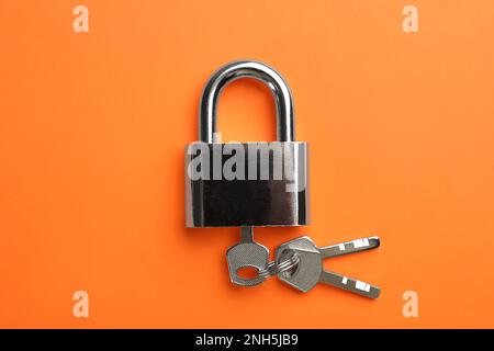 Cadenas moderne avec touches sur fond orange, vue de dessus Banque D'Images