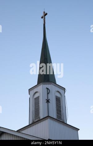 St. L'église catholique de Joseph Steeple avec un symbole de Pax Christi sur elle et une croix au sommet. Blanc avec un dessus gris. Banque D'Images