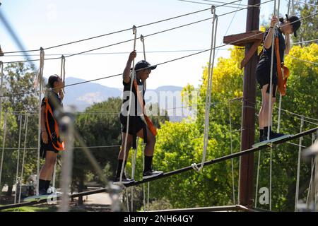 Les candidats de la Sunburst Youth Challenge Academy, base d'entraînement des forces interarmées, en Californie, se déplacent vers l'avant pour terminer le cours de corde au Orange County Rows course à Anaheim, en Californie, en 19 juillet 2022. Certains candidats hésitaient à continuer sur certains des obstacles, mais étaient motivés et encouragés par leurs pairs qui ont suivi le cours. Banque D'Images