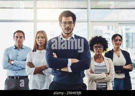 C'est une force avec laquelle il faut compter. Portrait d'un groupe d'hommes d'affaires debout avec leurs bras croisés dans un bureau. Banque D'Images