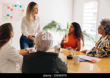 Groupe de femmes d'affaires multiculturelles ayant une discussion au cours d'une réunion. Diverses femmes d'affaires remue-méninges dans une salle de réunion. Femmes d'affaires créatives Banque D'Images
