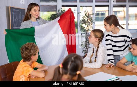 Professeur montrant le drapeau d'Italie à un groupe d'écoliers Banque D'Images