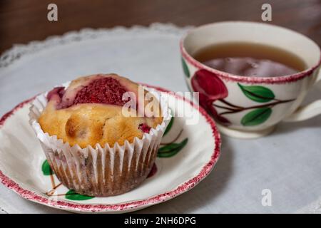 Muffin aux fraises et thé aux herbes sur la vaisselle Blue Ridge Crabapple au-dessus d'un méli blanc à Taylors Falls, Minnesota, États-Unis. Banque D'Images