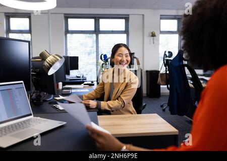 Bonne femme d'affaires asiatique au bureau, parlant avec une collègue au bureau Banque D'Images