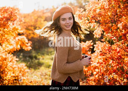 Belle jeune femme dans le beret debout dans le parc d'automne. Jeune femme tendance de cheveux bruns à l'automne dans la rue. Concept de l'ambiance d'automne. Copier l'espace Banque D'Images