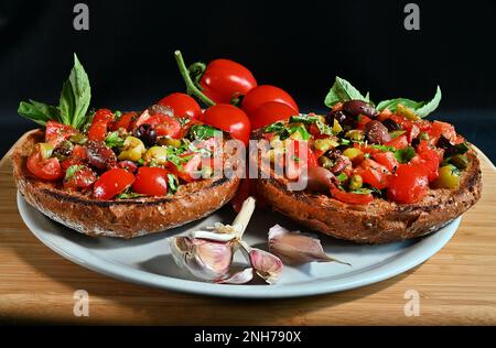 Bruschetta traditionnelle des Pouilles du sud de l'Italie avec tomates fraîches, basilic, olives, origan, huile d'olive. Le régime méditerranéen est ici. Banque D'Images