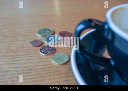 quelques pièces de monnaie sur la table pour payer une tasse de café dans une cafétéria Banque D'Images