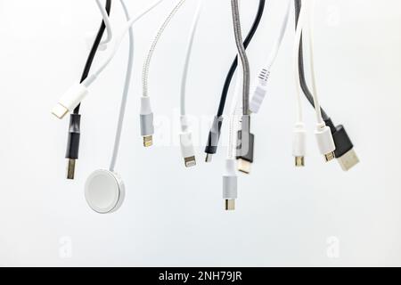 Un enchevêtrement de fiches, de prises et de câbles USB exposé dans le studio sur un arrière-plan blanc Banque D'Images