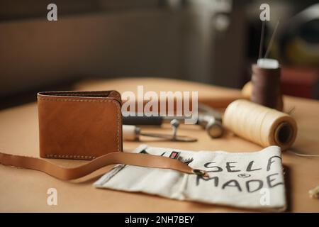 Outils de couture de produits en cuir sur la table, fil, aiguille et marteau. Banque D'Images