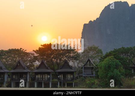 Coucher de soleil avec montgolfière à Vang Vieng, vue sur la montagne, bungalow au bord de la rivière, Vang Vieng, Laos Banque D'Images