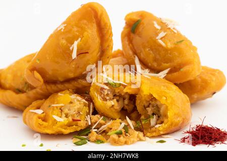 Kesar Gujia également appelé Gujiya, Pirukiya, Pirukia, Pedakiya, Karanji, Basundi ou Gughra farci de Mawa, Khoya, Chasni, Mava, Khoa - Dumpling indien Banque D'Images