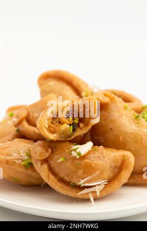 Gujia également appelé Gujiya, Pirukiya, Pirukia, Pedakiya, Karanji, Basundi ou Gughra farci avec Mawa, Khoya, Chasni, Mava, Khoa - Indian Sweet Dumpling Banque D'Images