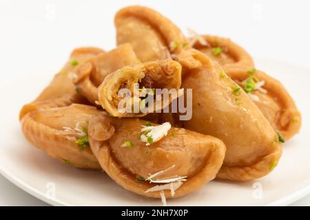 Gujia également appelé Gujiya, Pirukiya, Pirukia, Pedakiya, Karanji, Basundi ou Gughra farci avec Mawa, Khoya, Chasni, Mava, Khoa - Indian Sweet Dumpling Banque D'Images