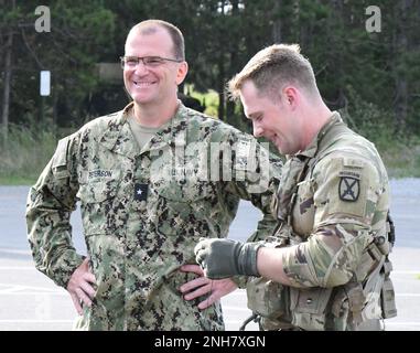 Le contre-amiral Eric L. Peterson, commandant adjoint de la Force médicale navale de l'Atlantique, parle avec le sergent d'état-major Nate Carey, un paramédic de vol du 3rd Bataillon de l'aviation de soutien général, 10th Brigade de l'aviation de combat, au début d'un exercice d'entraînement 21 juillet à l'extérieur du centre d'entraînement médical de simulation Bridgewater-Vaccaro (CMSTC) à fort Drum. Environ 60 hommes de corpmen de la Marine ont participé à l'opération Commandant Force, l'exercice annuel d'entraînement de deux semaines. L'événement qui a culminé a inclus des soins tactiques sur le terrain et des procédures d'évacuation médicale avec des réservistes passant par un cours d'obstacle à la portée. Banque D'Images