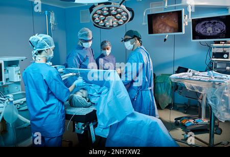 Chirurgiens travaillant sur le patient dans la salle d'opération moderne de l'hôpital. Travail d'équipe en service chirurgical Banque D'Images