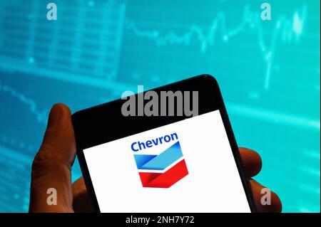 Chine. 15th févr. 2023. Dans cette illustration, le logo de la multinationale américaine Chevron Corporation, société pétrolière et gazière, est affiché sur un smartphone avec un graphique d'indice boursier économique en arrière-plan. Crédit : SOPA Images Limited/Alamy Live News Banque D'Images