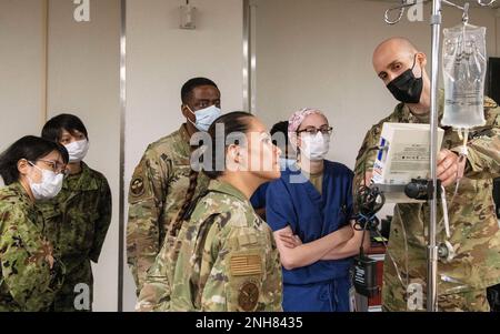 Le Maj Mark Pomerleau, intégrateur de soins de santé du Groupe médical 374th, explique la pompe d'analgésie contrôlée par le patient aux aviateurs de l'OMD 374th et aux instructeurs du Collège médical de la Défense nationale du Japon lors d'une immersion en sciences infirmières japonaises à 21 juillet 2022, à la base aérienne de Yokota, au Japon. Les étudiants et les instructeurs ont été invités à former avec leurs homologues américains dans un effort continu pour présenter les capacités médicales de Yokota tout en renforçant les partenariats avec l'avenir des praticiens des soins intensifs du Japon. Banque D'Images