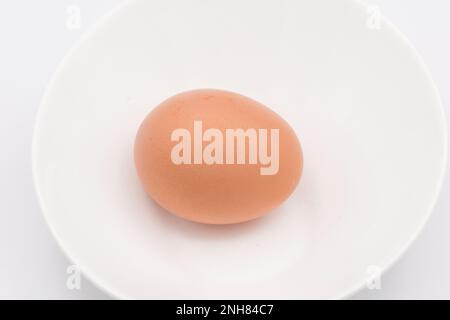 Un œuf de poulet dans un bol blanc Banque D'Images
