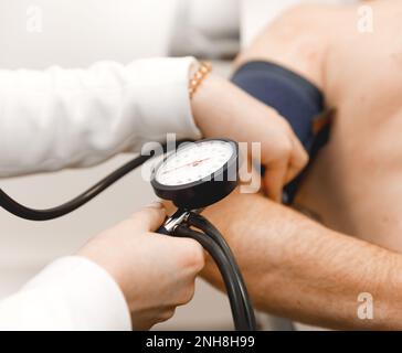 Médecin vérifiant la pression artérielle de l'ancien homme. soins de santé. Concept médical Banque D'Images