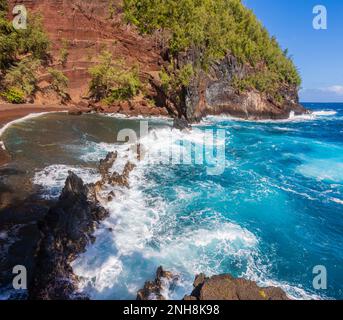 Sable rouge et vagues bleues de Kaihalulu Beach, Hana, Maui, Hawaii, États-Unis Banque D'Images