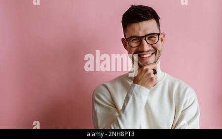 Portrait d'un homme à barbe heureux portant des lunettes riant et regardant l'appareil photo tout en posant Banque D'Images